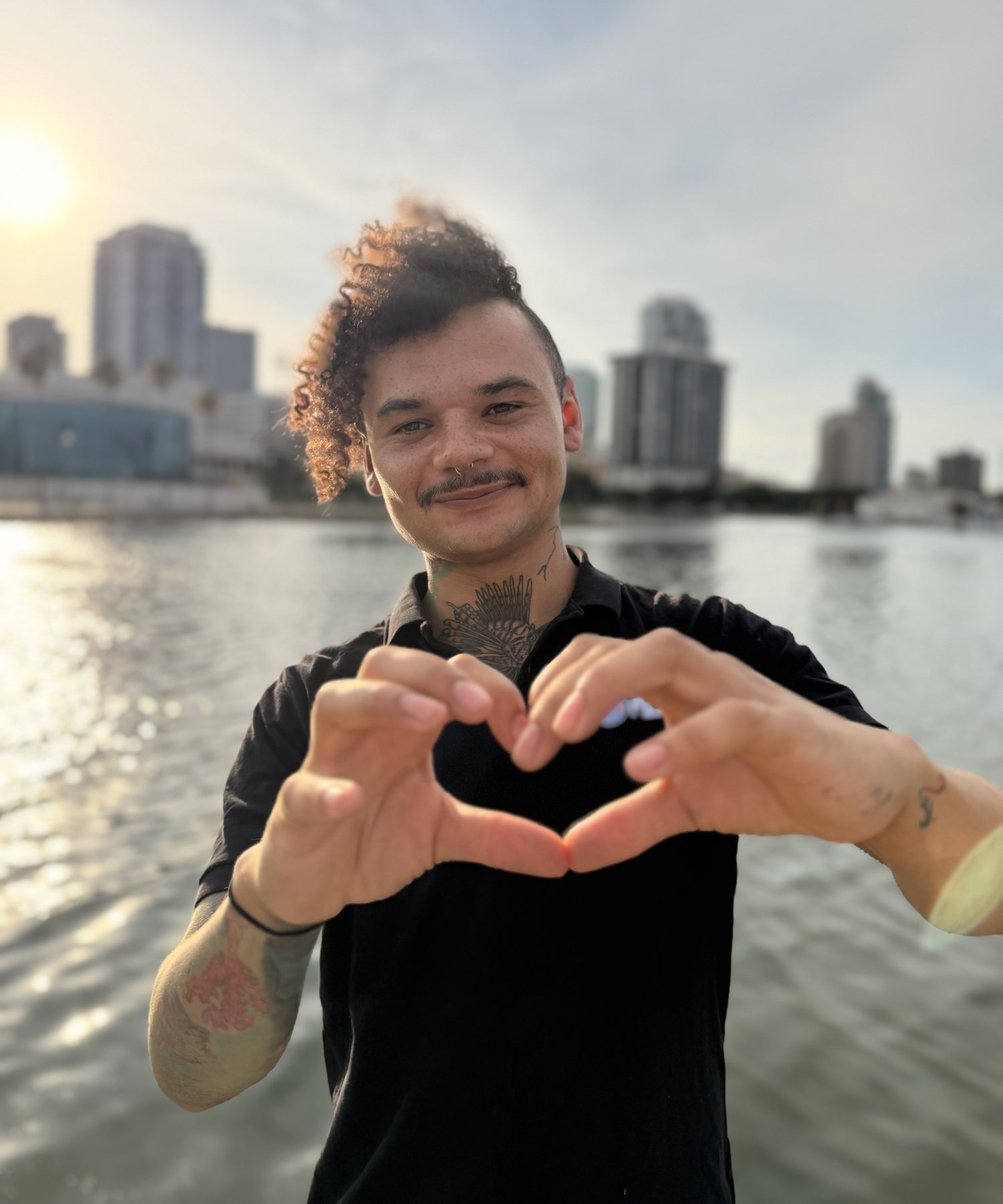 Jarrett Maryon of Misting Monsoon Diving making a heart with his hands on the St. Petersburg waterfront