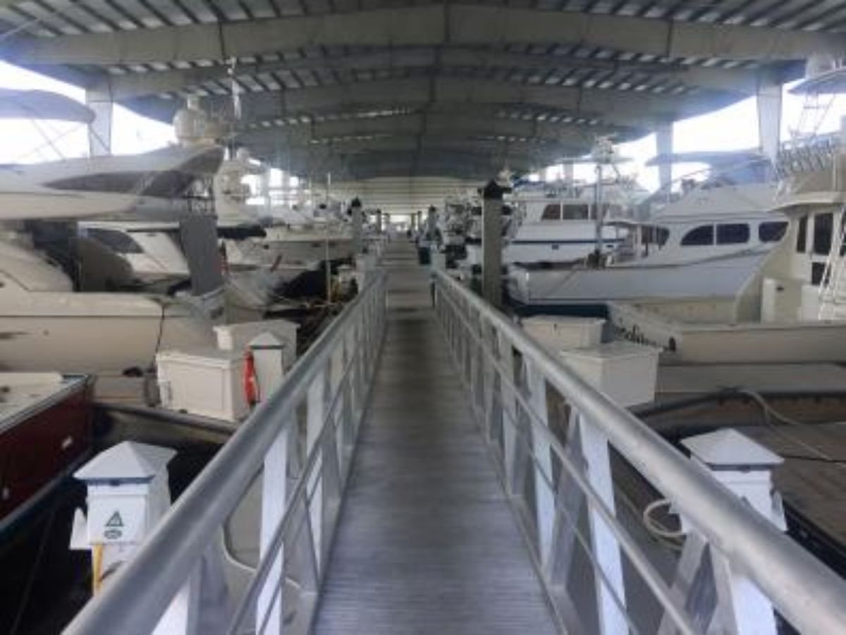 Interior of a covered slip row at Maximo Marina, boats berthed under roof.