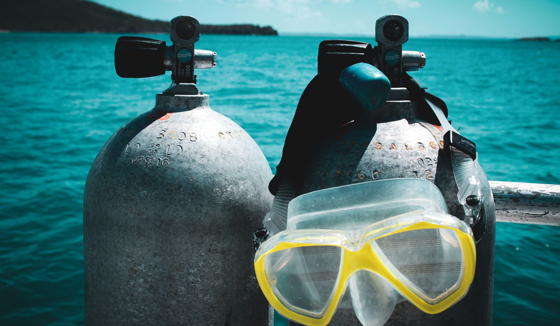 Scuba tanks and mask staged on a dive boat